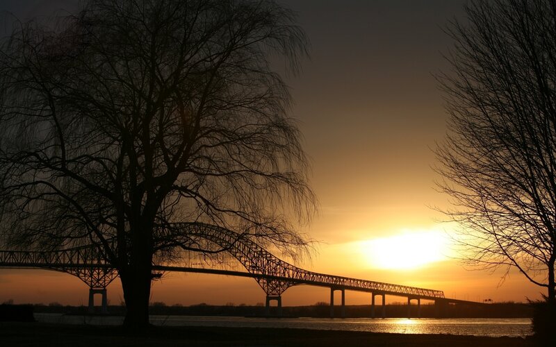 Silhouette of Bridge at Sunset — Orange, Serene, Photograph, Tree, River, Sky