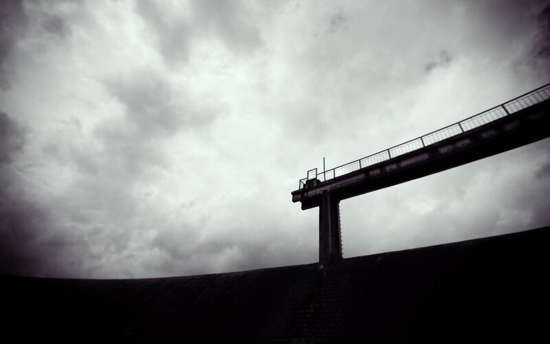 silhouette of bridge under cloudy sky