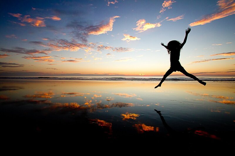 Silhouette of child jumping on beach