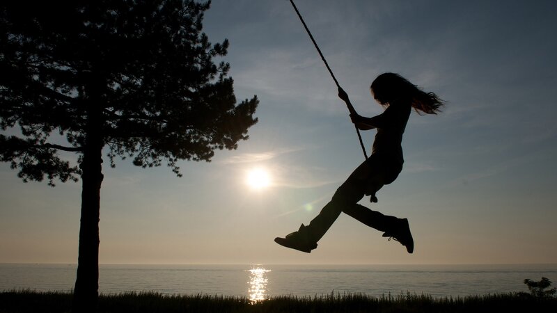 Silhouette of child on swing