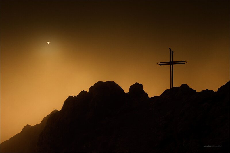 Silhouette of cross on mountain