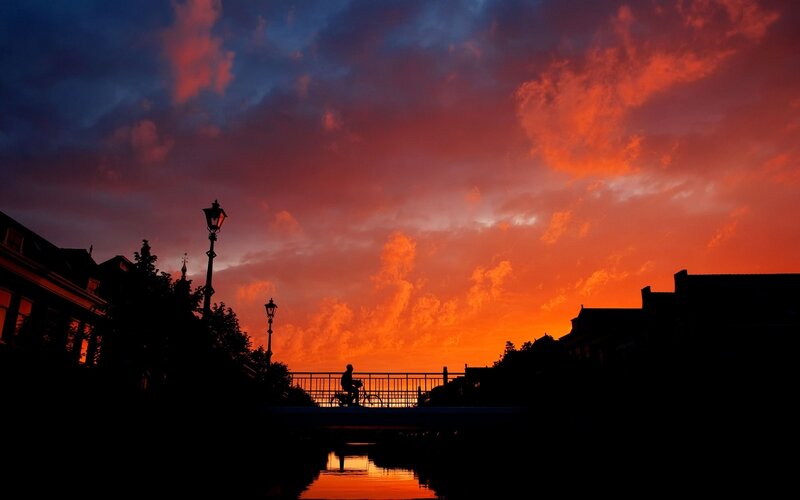Silhouette of Cyclist on Bridge — Orange, Dramatic, Sunset