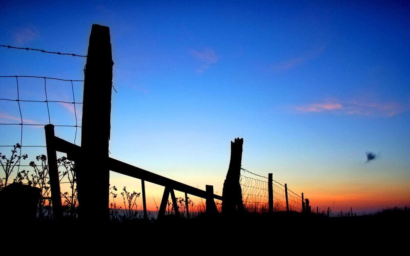 Silhouette of fence at sunset