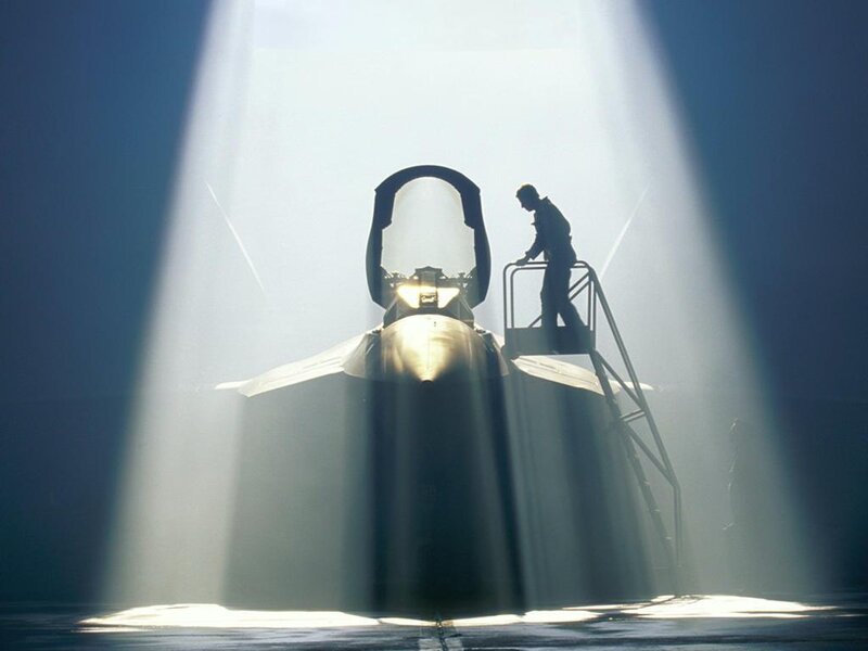 silhouette of fighter jet and technician
