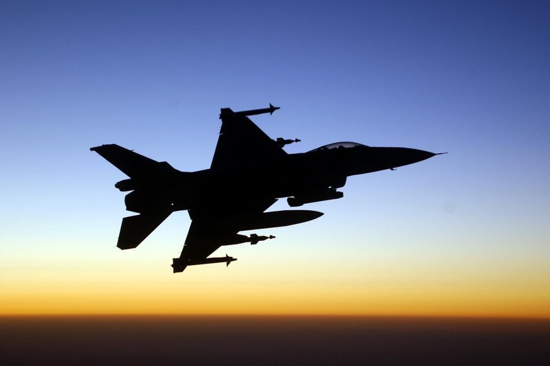 silhouette of fighter jet at sunset