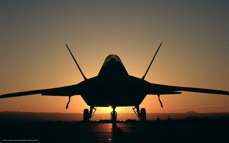 silhouette of fighter jet at sunset