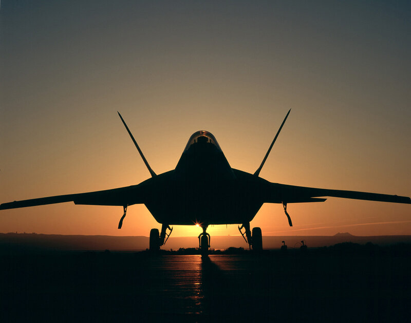 Silhouette of fighter jet at sunset