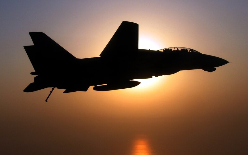 silhouette of fighter jet at sunset