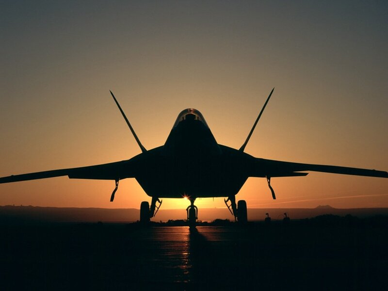 Silhouette of fighter jet at sunset