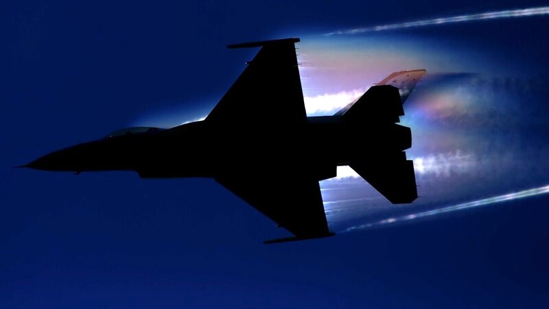 silhouette of fighter jet in flight