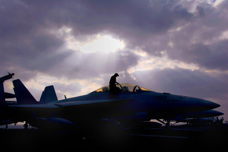 Silhouette of fighter jet on aircraft carrier