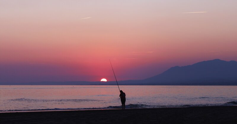 Silhouette of fisherman at sunset