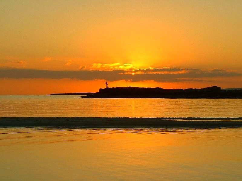 Silhouette of fisherman at sunset