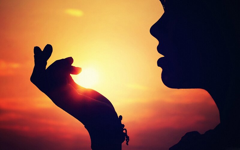 silhouette of hand and face at sunset