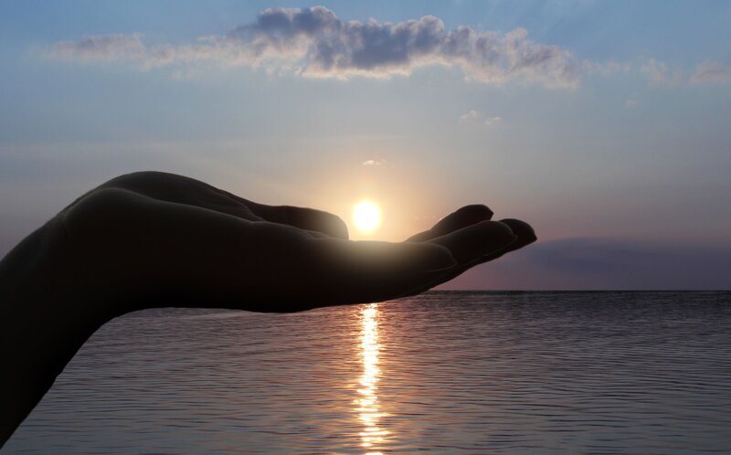 Silhouette of Hand Holding Sun