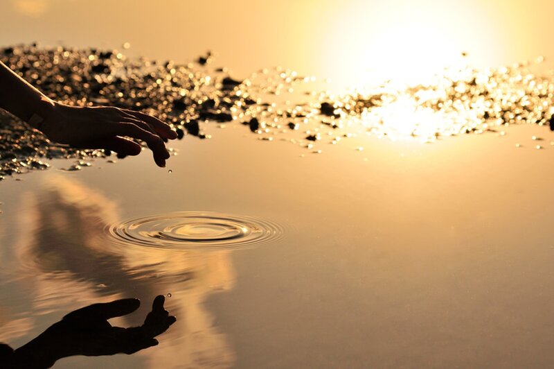 Silhouette of Hands Touching Water