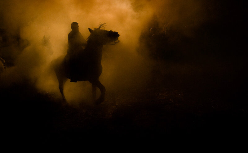 Silhouette of horse and rider in smoke