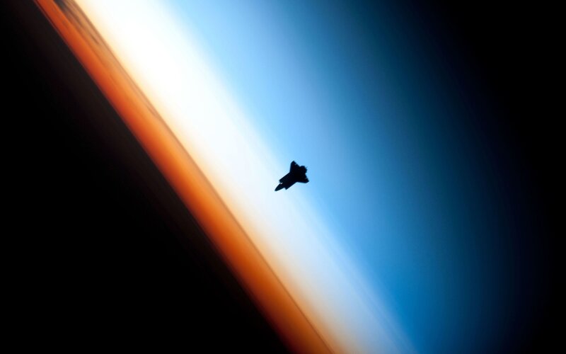 silhouette of jet over earth
