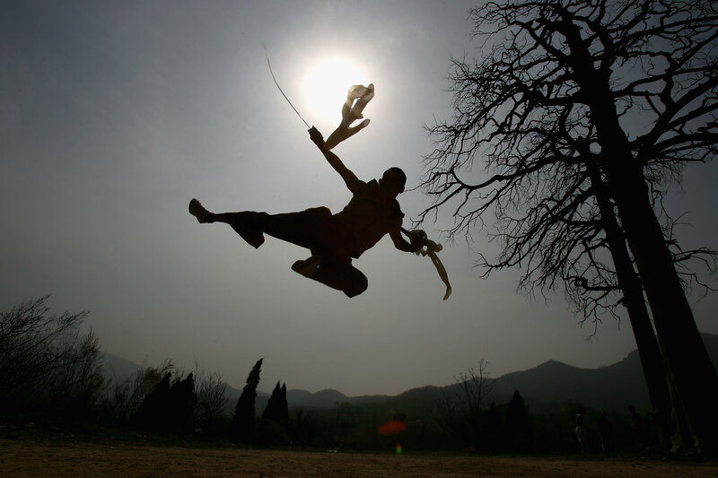 Silhouette of martial artist in mid-air