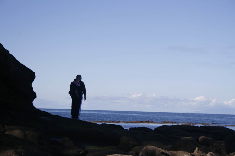Silhouette of parent with child at the coast