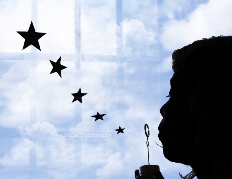 Silhouette of Person Blowing Bubbles