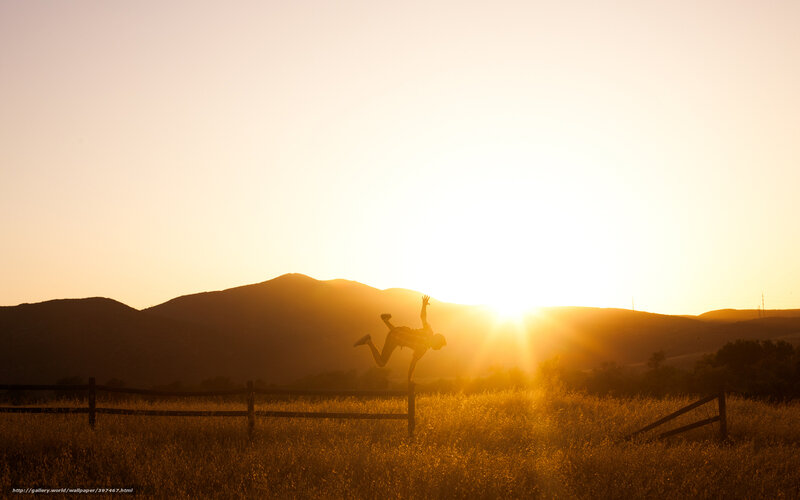 Silhouette of person jumping at sunset