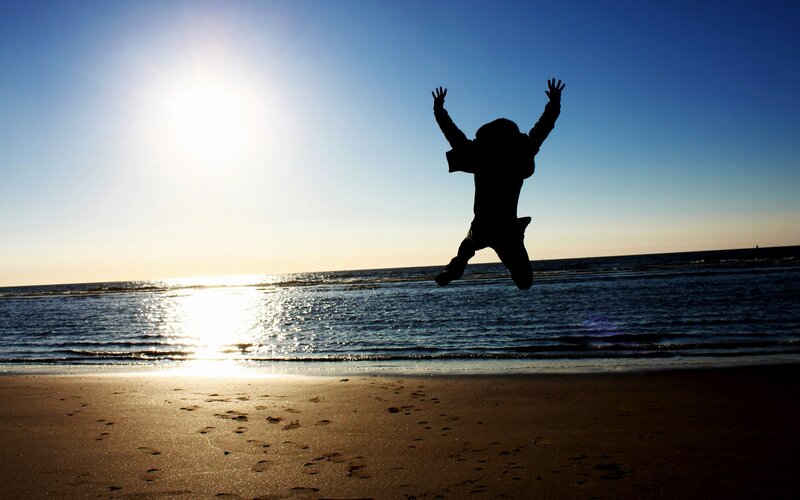 Silhouette of person jumping on beach