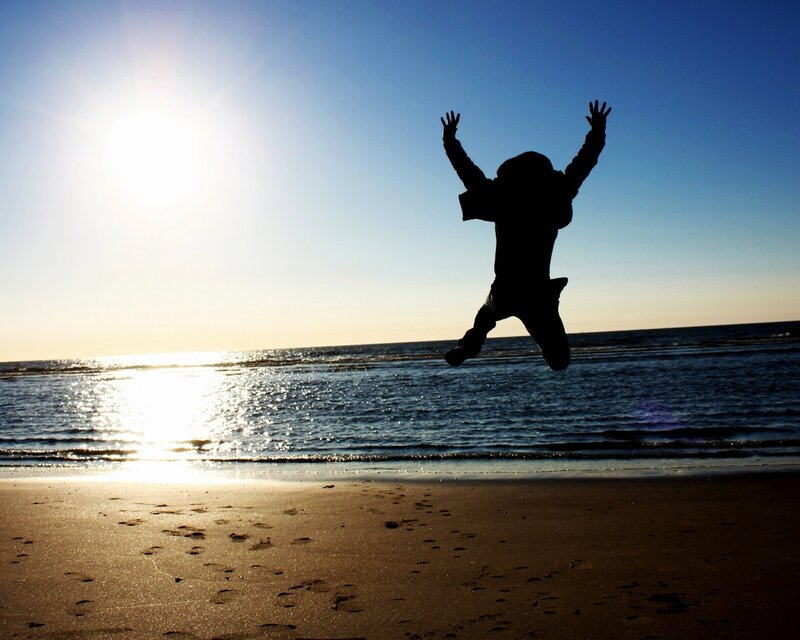 Silhouette of person jumping on beach