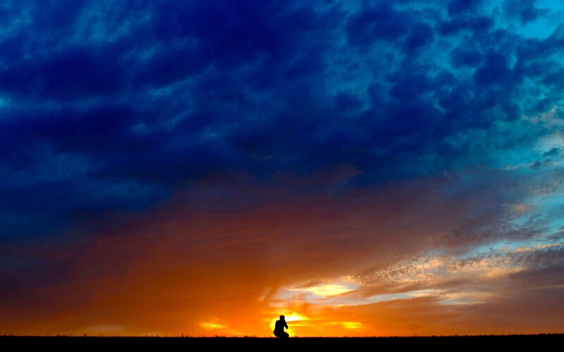 Silhouette of Person Kneeling — Blue, Dramatic, Sunset