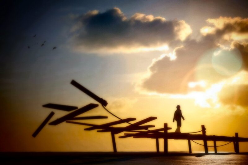 Silhouette of person on broken pier