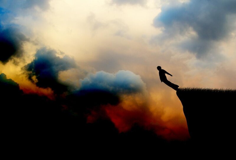 Silhouette of person on cliff edge
