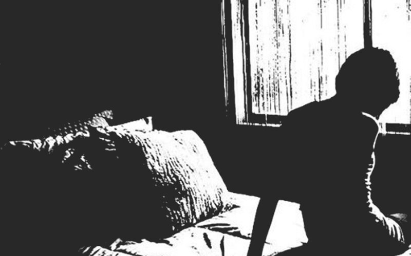 silhouette of person sitting on bed