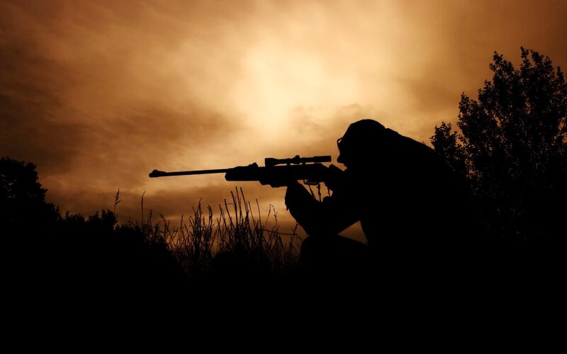 Silhouette of sniper at sunset