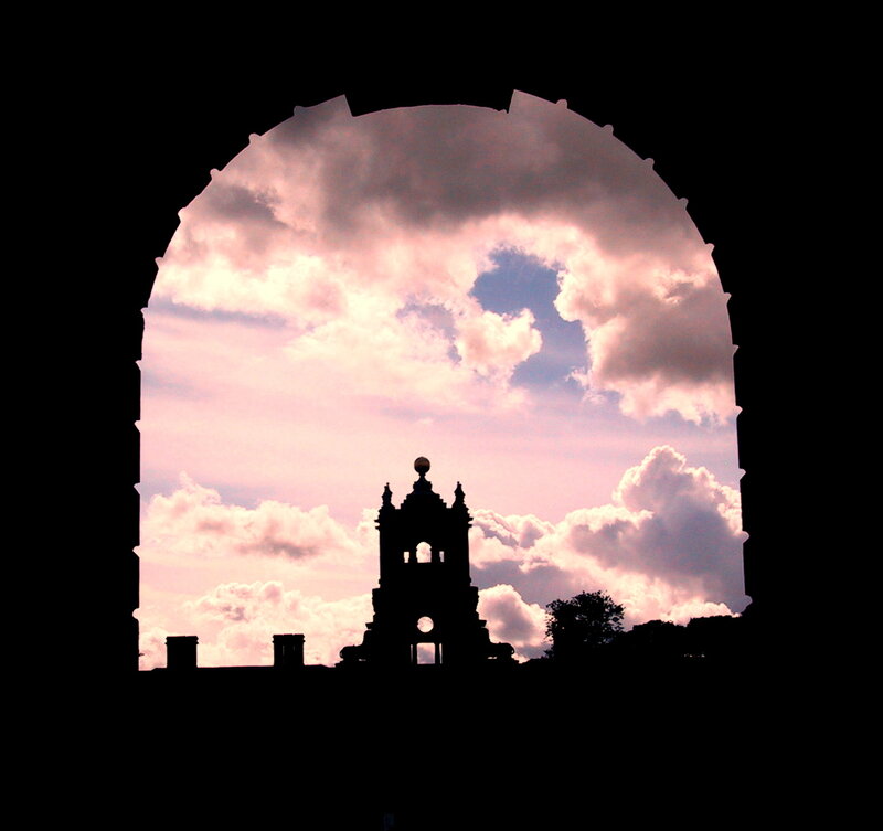silhouette of tower through arch