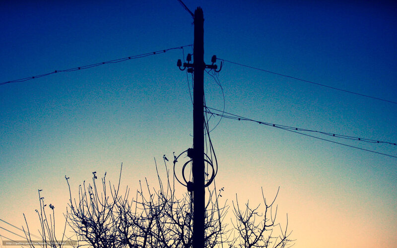 Silhouette of utility pole at dusk