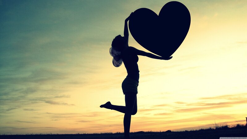 Silhouette of woman holding heart