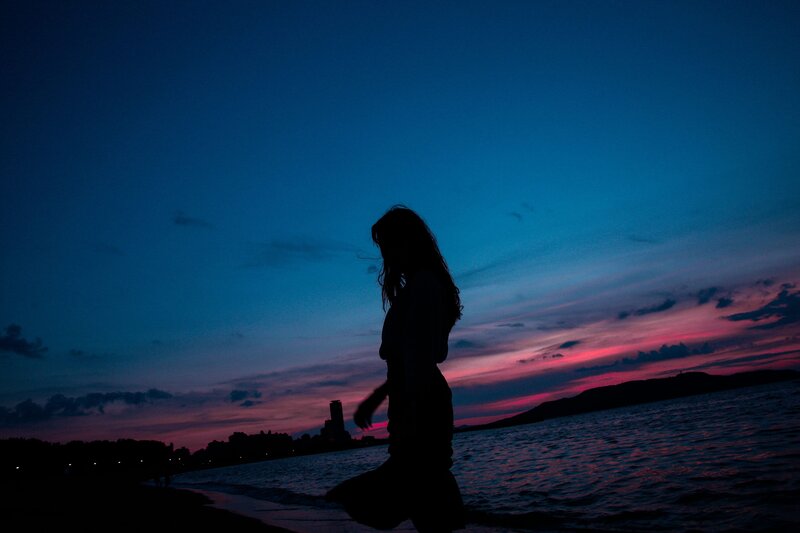 Silhouette of Woman on Beach — Blue, Dramatic, Sunset, Photograph, Sky