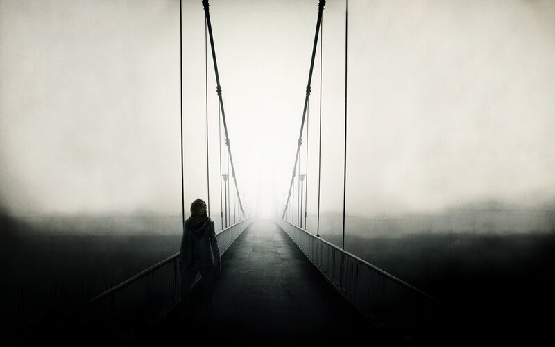 Silhouette on a foggy bridge