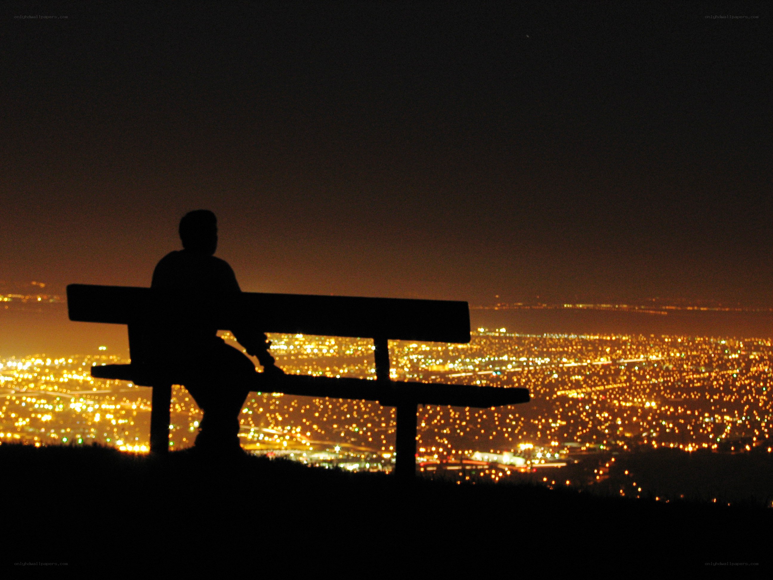 Silhouette on bench at night