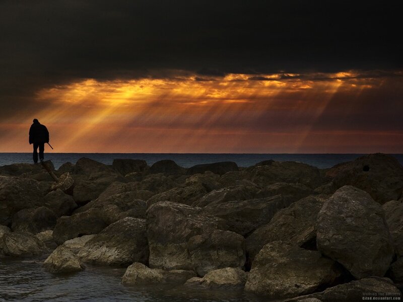 Silhouette on rocky shore at sunset