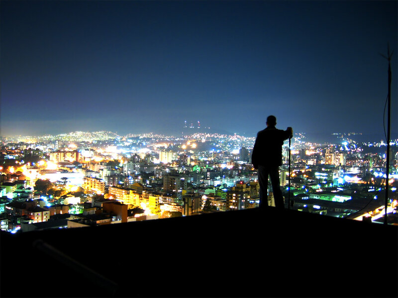 Silhouette overlooking city at night