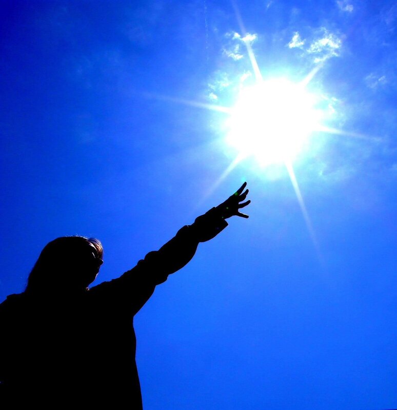 silhouette reaching for sun