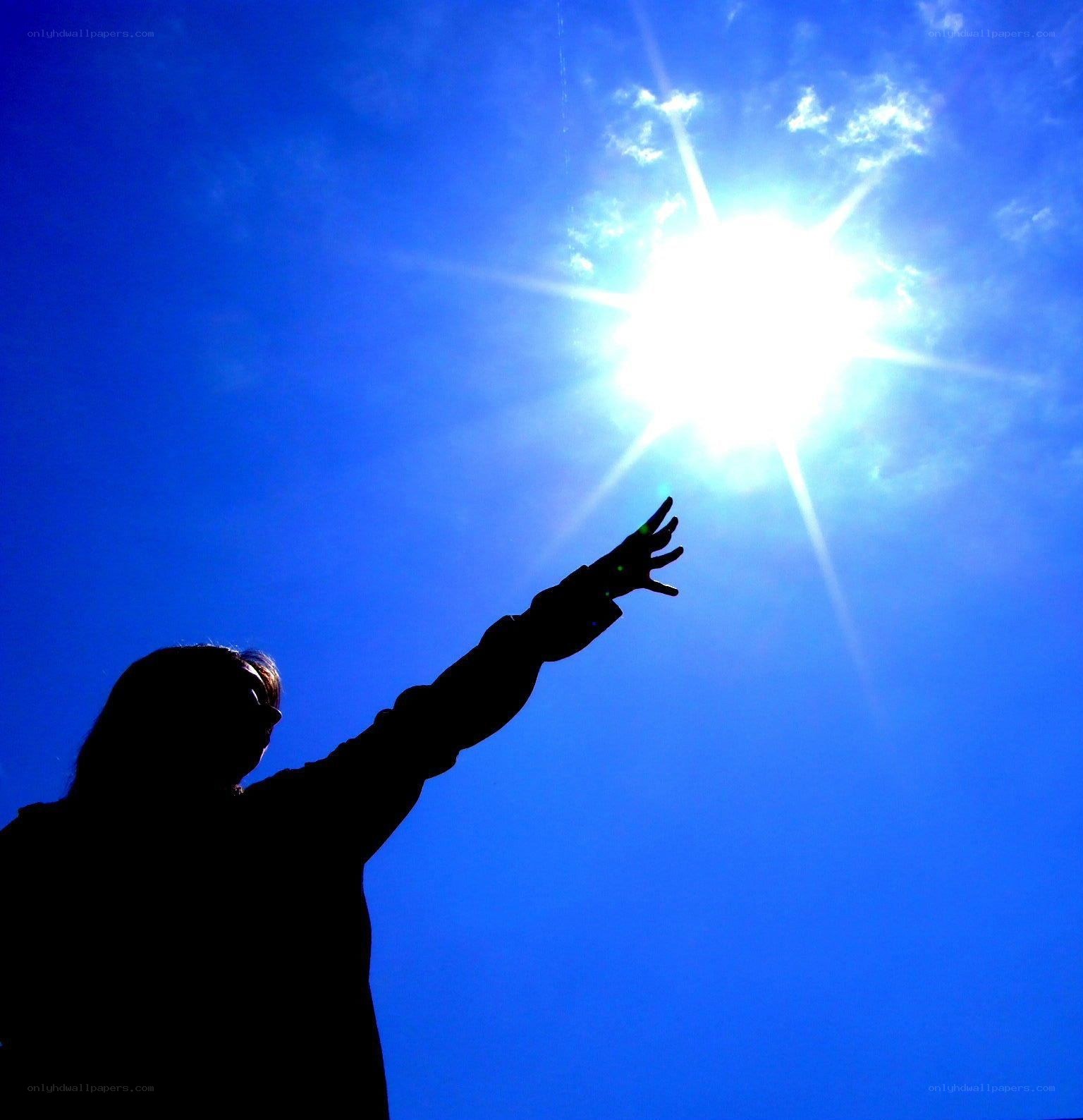 silhouette reaching for sun