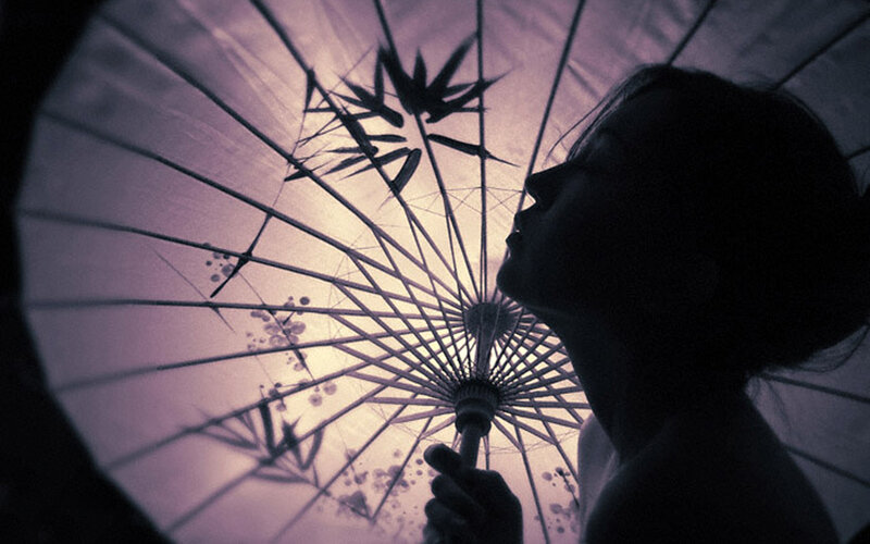 Silhouette under paper umbrella