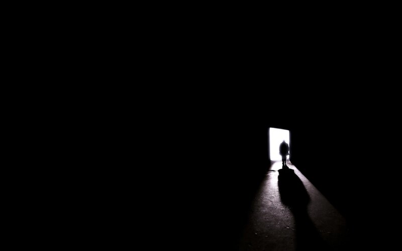 silhouette walking toward light