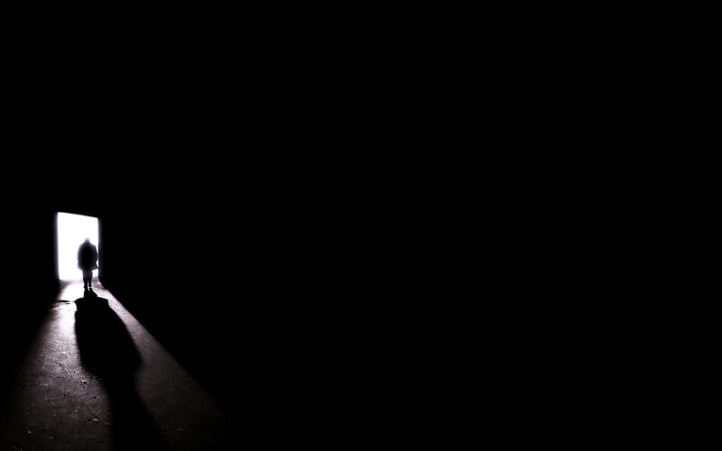 silhouette walking toward light