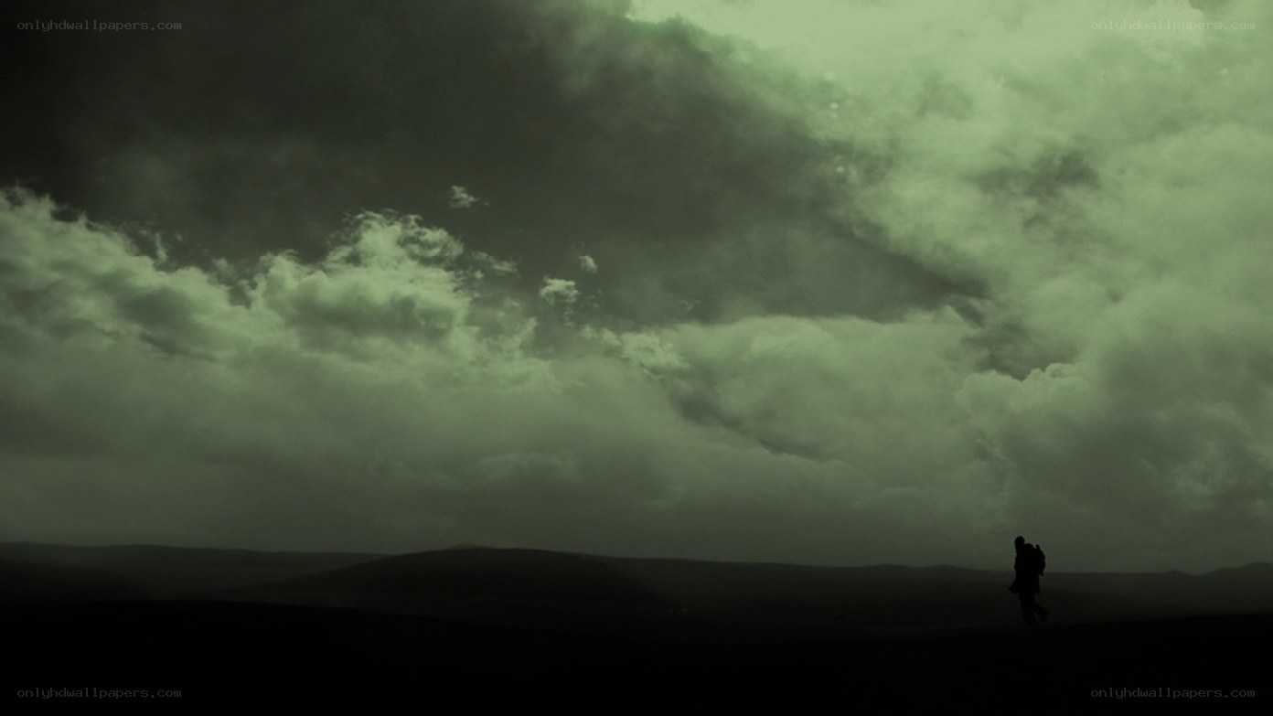 silhouette walking under stormy sky