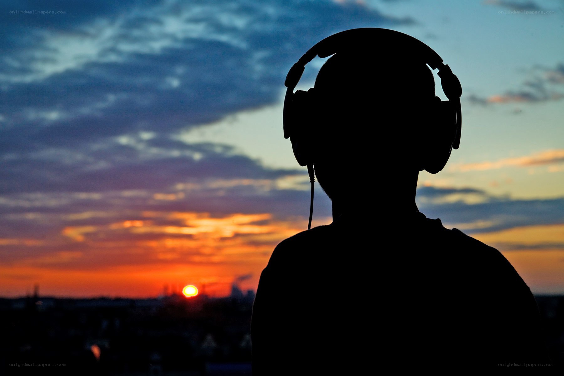 Silhouette with headphones at sunset
