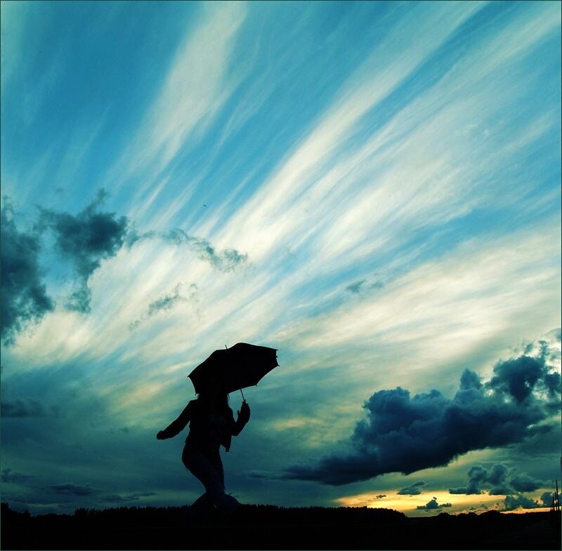 Silhouette with umbrella at sunset