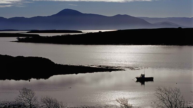 Silhouetted boat on a calm bay